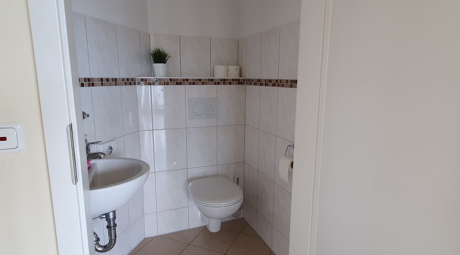 Paar entspannt im Bett und isst Erdbeeren unter einem Wandbild mit Fischerboot